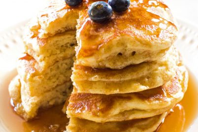 Fluffy pancakes and blueberries with syrup on a plate